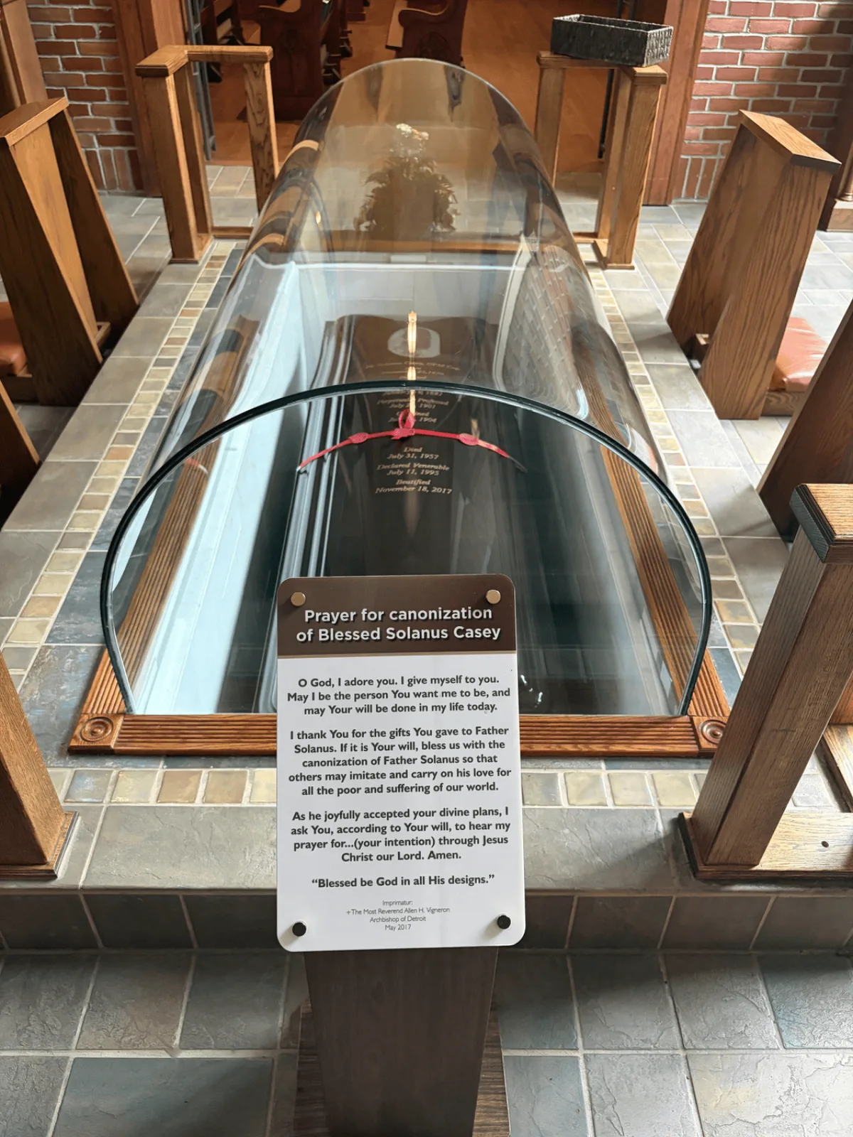The glass sarcophagus and plaque marking the tomb of Blessed Solanus Casey